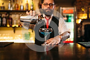 Bartender with shaker making alcohol cocktail
