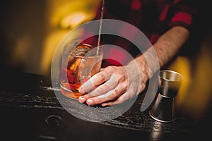 Bartender is stirring cocktails on bar counter