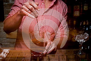 Bartender is stirring cocktails on bar counter