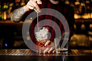 Bartender stirring a Foreign Legion cocktail with the spoon