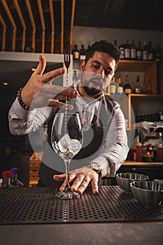 Bartender stirring ice cubes