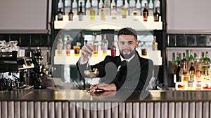 Bartender stirring with spoon cocktail in golden wine glass