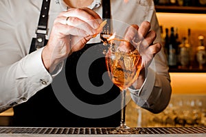 Bartender in a white shirt making a cocktail with a smoky note