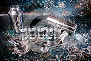 Bartending tools with cocktail shaker, shot glasses and alcoholic drinks. Bar details, nightlife glass alcoholic shots