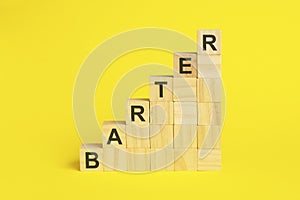 BARTER - text on wooden cubes, yellow background