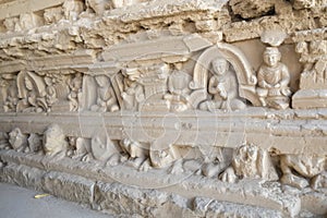 Bas-relief of Buddha and monks on the Stupa at Jaulian monastery.