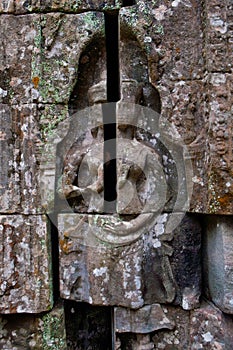 Bas-relief depicting ancient stories on the walls of Ta Phrom temple ruins, Angkor Wat Cambodia. photo