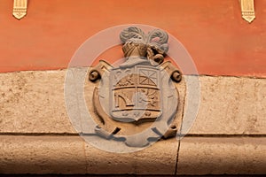 Bas-relief of old coat of arms shield on the entrance with eagle, horse and helmet