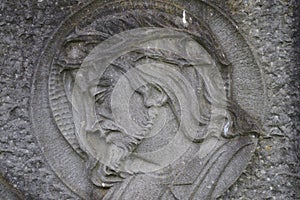 Bas relief sculpture of a suffering Jesus Christ on a grave. Historic graveyard.