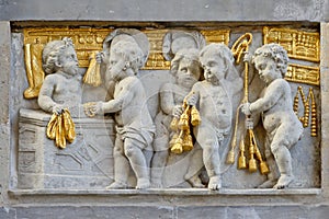 Bas relief in stone and gold of working cherubs