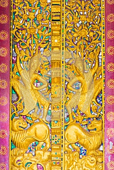 Bas-relief on the wall of the temple Wat Sensoukaram in Louangphabang, Laos. Vertical. Close-up.