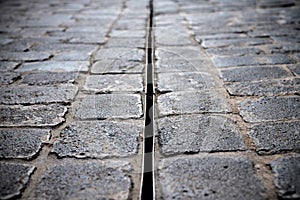 Basalt cobble stones and a rain gutter in the street.