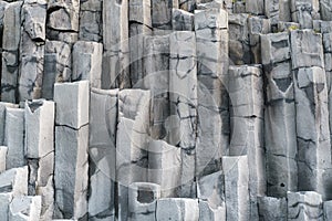 Basalt rock pillars columns at Reynisfjara beach near Vik, South Iceland. Unique geological volcanic formations. Natural stone