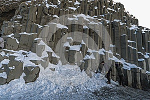 Basaltic or HÃ¡lsanef snow columns from below Reynisfjara Black Beach or VÃ­k Black Beach with clear sky about to snow