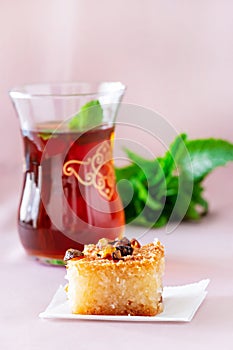 Basbousa or Namoora traditional arabic dessert and mint tea. Delicious homemade semolina cake. Copy space. Selective focus
