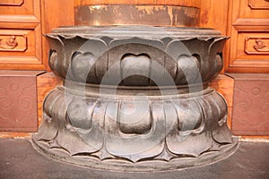 The base of a column shaped like a metal lotus flower