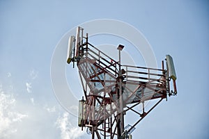 Base transceiver station (BTS) with antenna isolated on blue sky background. Telecommunications radio tower cells