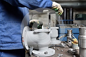 The base for the valve is mounted on an iron table for assembly at the factory and the worker installs and fastens the