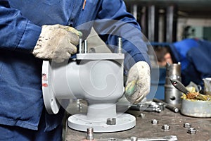 The base for the valve is mounted on an iron table for assembly at the factory and the worker installs and fastens the