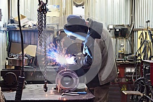 The base for the valve is mounted on the iron table at the factory and the worker welds with a welding machine. Sparks