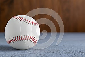 Baseball ball on grey wooden table, closeup. Space for text