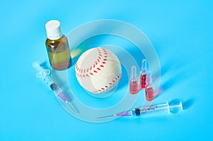 Baseball ball near syringe and ampoule, bottle on blue background. Concept of doping in sport