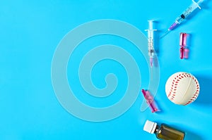 Baseball ball near syringe and ampoule, bottle on blue background. Concept of doping in sport