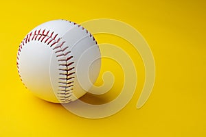 Baseball ball on yellow background with copy space