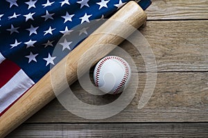 baseball and baseball bat with American flag on wooden table background