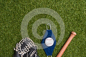 Baseball bat, ball, glove and mask isolated on a field of grass. Baseball season with face mask. Safe sport concept