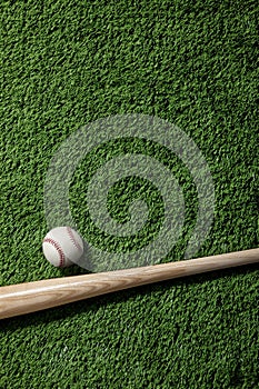 Baseball bat and ball on green turf background