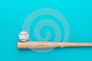 Baseball bat and ball on turquoise blue