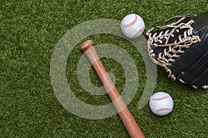 Baseball bat, glove and ball on green grass field.  Sport theme background with copy space for text and advertisment