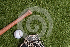 Baseball bat, glove and ball on green grass field.  Sport theme background with copy space for text and advertisment