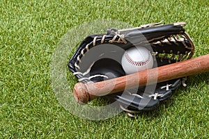 Baseball bat, glove and ball on green grass field. Sport theme background with copy space for text and advertisment photo