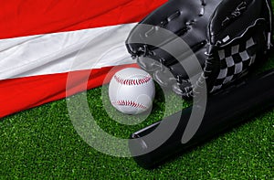 Baseball bat, glove and ball near Austria flag on green grass background