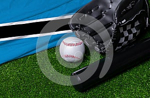 Baseball bat, glove and ball near Botswana flag on green grass background