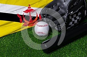 Baseball bat, glove and ball near Brunei flag on green grass background