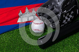 Baseball bat, glove and ball near Cambodia flag on green grass background