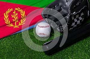 Baseball bat, glove and ball near Eritrea flag on green grass background