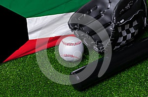 Baseball bat, glove and ball near Kuwait flag on green grass background