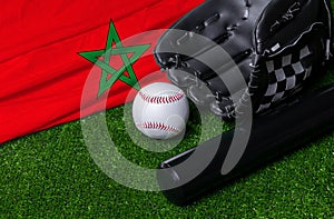 Baseball bat, glove and ball near Morocco flag on green grass background