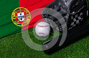 Baseball bat, glove and ball near Portugal flag on green grass background