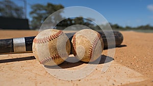 BASEBALL AND BAT ON HOME PLATE