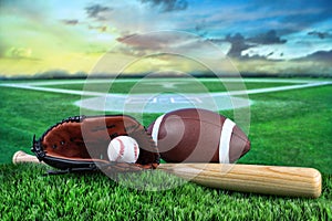 Baseball, bat, and mitt in field at sunset photo