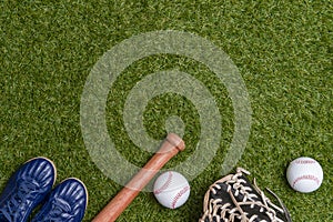 Baseball bat,shoes, glove and ball on green grass field. Sport theme background with copy space for text and advertisment