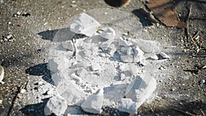 A baseball bat smashes a white brick into small pieces. Close up. Strong blow