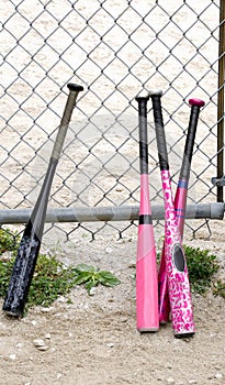 Baseball bats against a chain link fence