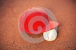 Baseball cap and ball on field