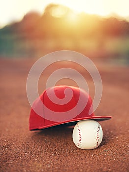 Baseball cap and ball at sunset